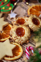 Thumbprint apricot jam and nuts Christmas cookies on holiday background