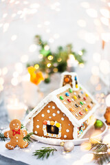Homemade Christmas gingerbread house with holiday   decorations, candles and lanterns on  background