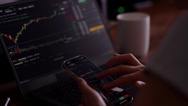 Investor Analyzing Stock Market Charts Using Smartphone And Laptop. Trader Trading Crypto Currency. Financial Graph 