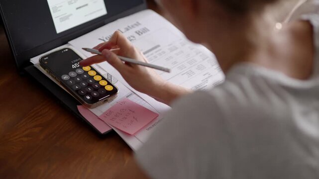 Homeowner Calculating Energy Bill Expenses Using Smartphone Calculator. Managing Household Budgetv And Utility Costs