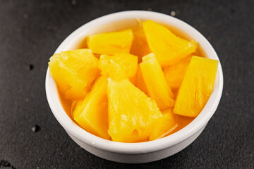 Pineapple canned chunks sweet fruit dessert tasty snack fresh delicious gourmet food background on the table rustic top view copy space keto and paleo diet vegetarian and vegan food