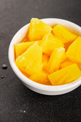Pineapple canned chunks sweet fruit dessert tasty snack fresh delicious gourmet food background on the table rustic top view copy space keto and paleo diet vegetarian and vegan food