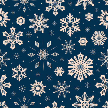 Snowflakes seamless pattern on navy blue background. Christmas and New year holiday snow crystals stars in night sky. Dark blue winter ornate repeat design for textile fabric, wrapping paper print.