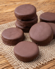 Brazilian Pao de Mel or chocolate covered honey cookies over a wooden table