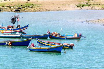Naklejka premium Rabat, Morocco – A scenic view of the Bou Regreg River with colorful fishing boats gently floating on the water