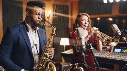 Professional musicians playing saxophone and trumpet in a recording studio with advanced audio equipment