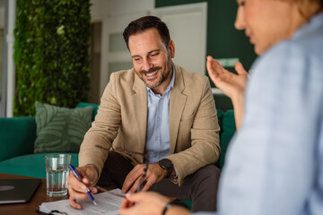 Business professional discussing contract with client during meeting