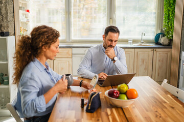 Couple working together from home, multitasking during morning routine