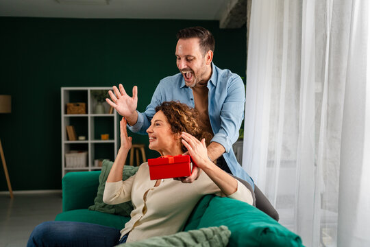 Partner surprising woman with anniversary gift and celebration - Powered by Adobe