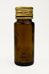 Glass pill bottle with tablets on white background – pharmaceutical medicine, vitamins, healthcare concept.