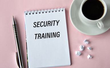 SECURITY TRAINING - words in a notebook on a pink background with a cup of coffee