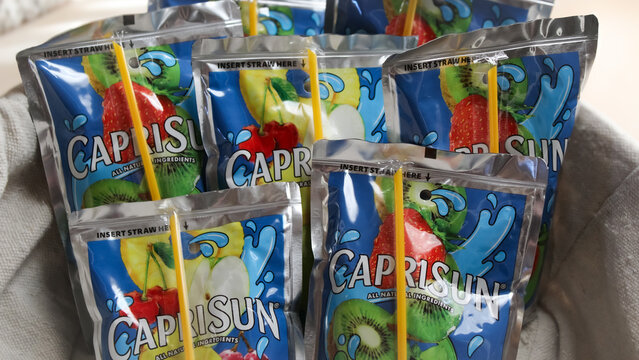 Minneapolis, USA - Nov. 11, 2025: Close-up of a collection of Capri Sun juice drink pouches in a basket featuring all-natural ingredients. For Editorial Use Only.