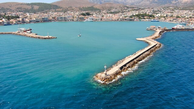 Aerial drone view of the main port of Chios, Greece. Ferries, harbor infrastructure, waterfront urban landscape and clear Aegean waters. High-resolution Mediterranean maritime and travel photography.