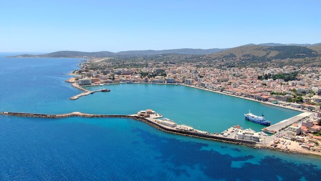 Aerial drone view of the main port of Chios, Greece. Ferries, harbor infrastructure, waterfront urban landscape and clear Aegean waters. High-resolution Mediterranean maritime and travel photography. - Powered by Adobe
