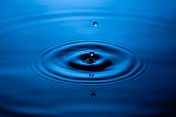 Blue Water drop falling, macro splash. Natural background