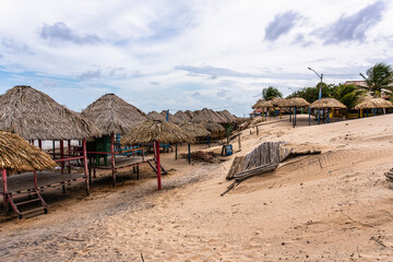 Colorful waters and natural-framed kiosks at Pesqueiro Beach, Soure in Marajo Island, Brazil
