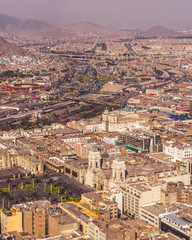 Fototapeta premium High-angle aerial view of Lima's historic center, featuring the Cathedral at Plaza de Armas, San Francisco Church, and the vast Pan-American highway.
