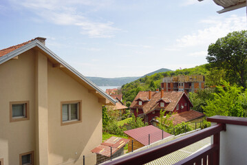 A peaceful town on the banks of the Danube, featuring small houses, buildings under construction, the river, and wind turbines on a hill. Represents evolving property landscapes and sustainable living