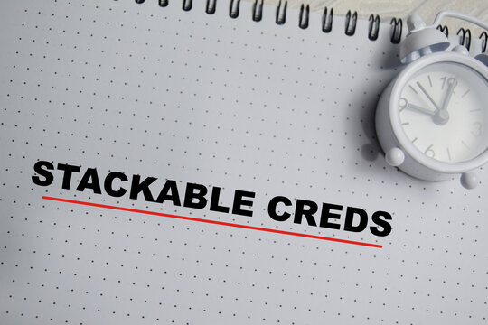 Concept of stackable creds write on book isolated on Wooden Table.