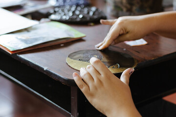 Adult hands creating art piece on desk, exploring creativity and craftsmanship in an art class setting