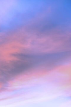 Sky with soft and fluffy pastel orange pink and blue colored clouds. Sunset background. Nature. sunrise. Vertical