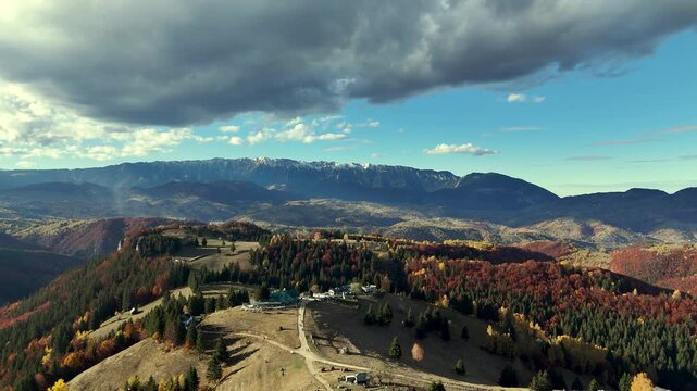 Autumn forest and snow-capped mountain peak in Moeciu de Sus Romania