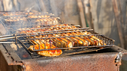 Grilled skewers of marinated meat and vegetables sizzling on a barbecue grill, surrounded by smoke and rustic outdoor ambiance