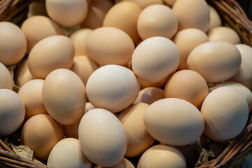 Brown and white eggs arranged on market counter. Local farm fresh eggs sold at outdoor market. Organic farm eggs for sale at farmers market.