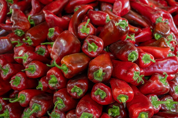 Fresh red capia peppers displayed at market stall. Heap of fresh capia peppers at vegetable stall. Organic capia peppers for sale at local bazaar.