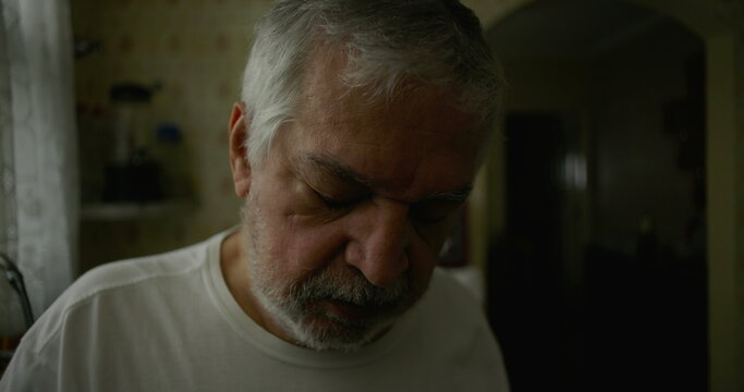 Close-up of elderly man in kitchen with introspective expression, representing solitude, aging, and moments of quiet reflection in domestic life - Powered by Adobe