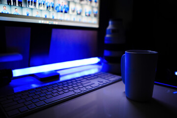 Minimalist workspace with mug / cup and computer keyboard, with Sony Mirrorless Lenses at night....