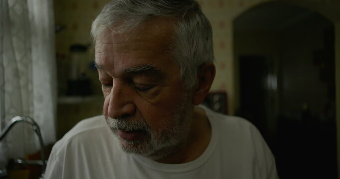 Close-up of elderly man in kitchen with introspective expression, representing solitude, aging, and moments of quiet reflection in domestic life - Powered by Adobe