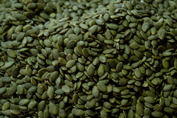 Shelled Pumpkin Seeds Displayed at Market Stall. Raw Pumpkin Seed Kernels for Sale at Local Market. Organic Shelled Pumpkin Seeds on Market Display.