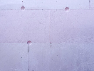 Insulation boards of extruded polystyrene foam (XPS) with anchor holes, showing thermal facade installation and construction texture for energy efficiency and modern architecture.