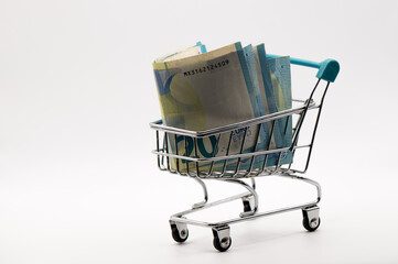 Twenty Euro Focus: Isolated Miniature Shopping Cart with Folded 20 Euro Banknotes, Representing Smaller Transactions
