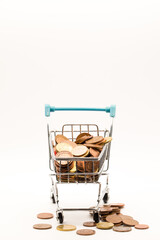Minimalist Finance Concept: Stacked Euro Coins in a Small Cart, Centered with Change Scattered Below.