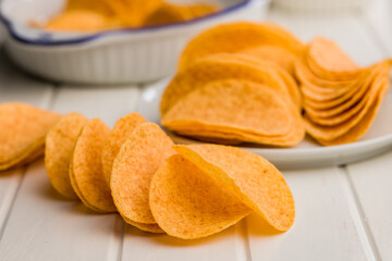 Crispy potato chips on white table.