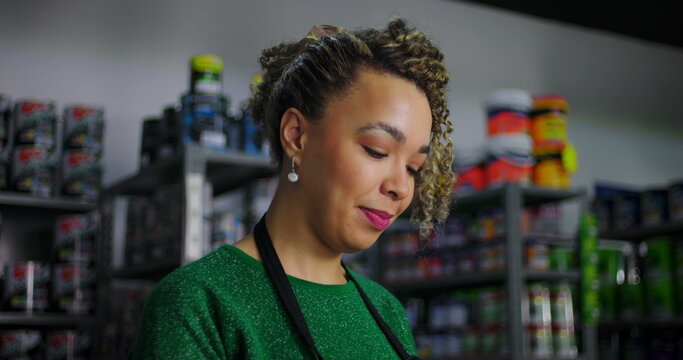 Shopkeeper managing messages on a smartphone in a hardware store, demonstrating professional multitasking and attention to business communication