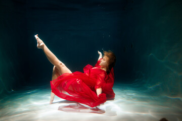 Lady in red beneath water, Redclad woman strikes pose underwater