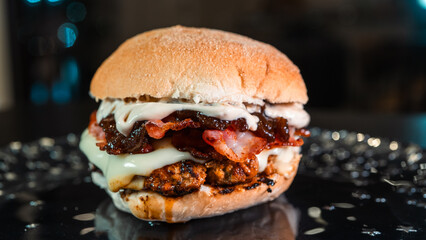 Juicy burger with special rub, melted cheese, onion chutney, and crispy bacon. Perfectly cooked and succulent, ideal for gourmet meals and promotions.