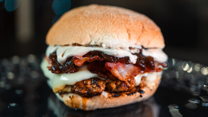 Juicy burger with special rub, melted cheese, onion chutney, and crispy bacon. Perfectly cooked and succulent, ideal for gourmet meals and promotions.