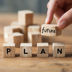 A hand arranging wooden cubes on a clean table with one block labeled “future” and another labeled “plan,” representing business vision, growth, and strategic planning