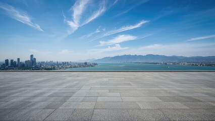 Urban cityscape with a waterfront and distant mountains under a clear blue sky.