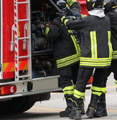 firefighters during the emergency while pulling the hose from the fire truck