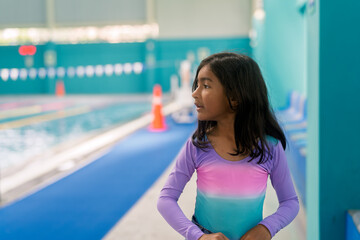 Young girl preparing for swimming lesson at indoor pool