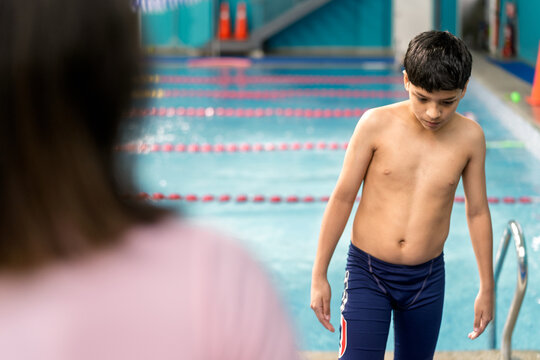 Child preparing for swimming lesson at indoor pool - Powered by Adobe