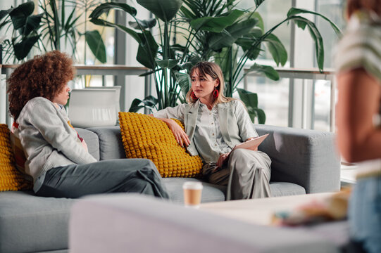 Women colleagues having meeting or break on sofa