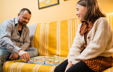 Happy father and child playing board game at home - happiness and family concept.