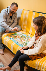Happy father and child playing board game at home - happiness and family concept.