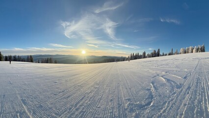 Snow-covered landscape at sunrise with clear sky and distant trees. Winter scene with snow and sunrise. Beautiful winter landscape with snow and sunrise.